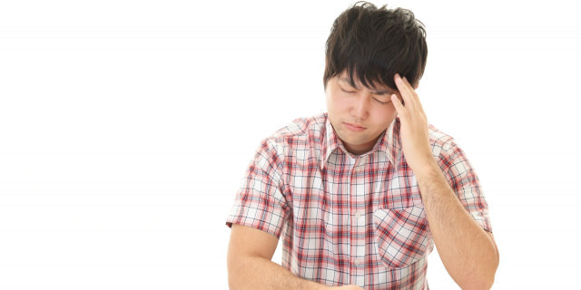 頭が痛そうな男性