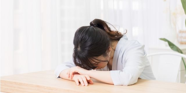 ご飯を食べながら考える女性